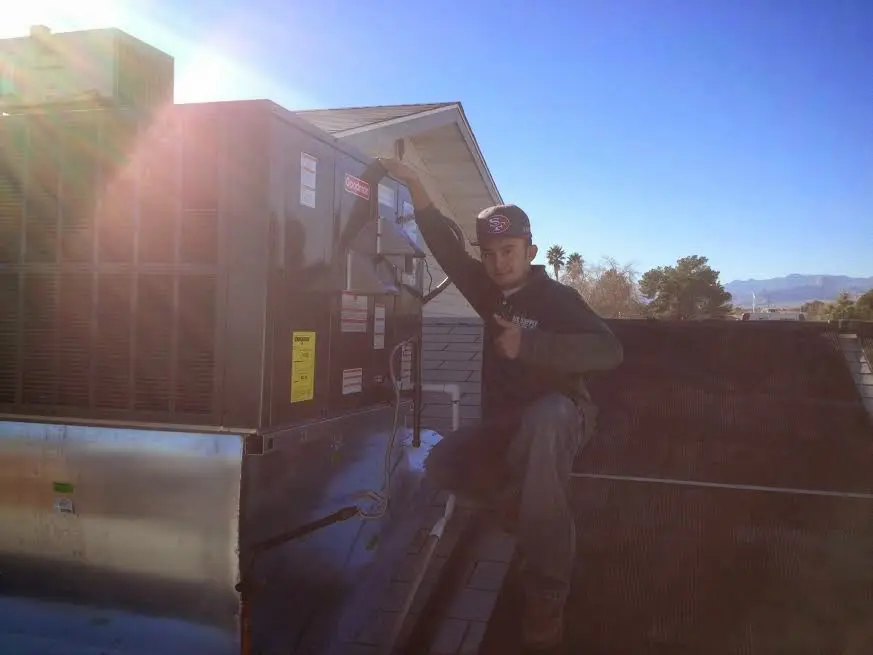 HVAC technician performing Heat Pump Repair on a rooftop unit in Duvall